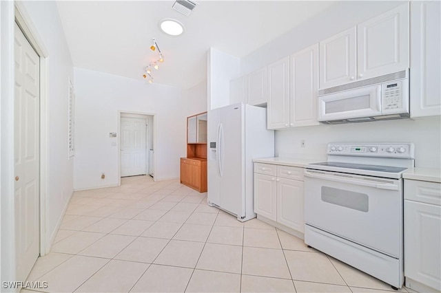 kitchen with white cabinetry, light tile patterned flooring, and white appliances