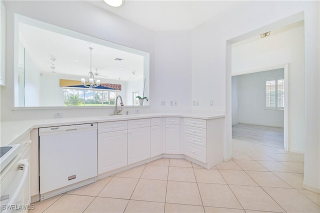 kitchen featuring dishwasher, white cabinets, sink, light tile patterned floors, and a chandelier