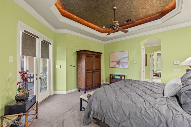 bedroom featuring ceiling fan, a raised ceiling, light colored carpet, and ornamental molding