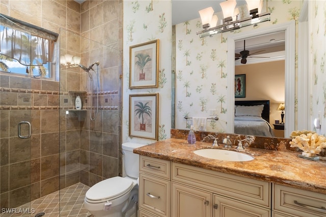 bathroom featuring vanity, ceiling fan, toilet, and a shower with shower door