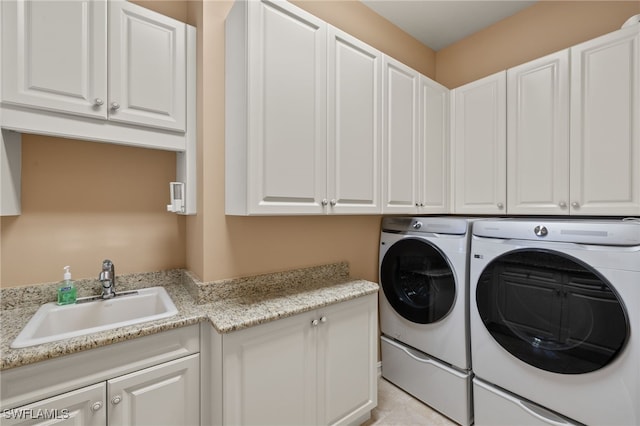 laundry room featuring separate washer and dryer, sink, and cabinets