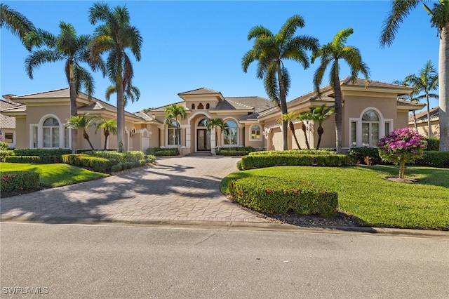 mediterranean / spanish house with a front lawn and a garage