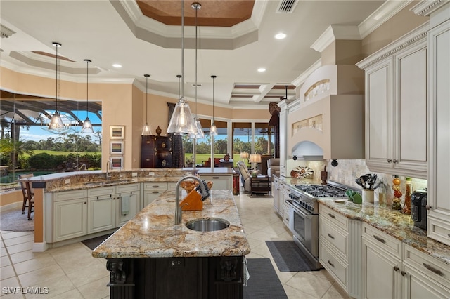 kitchen with high end stainless steel range oven, hanging light fixtures, a large island, and light stone counters