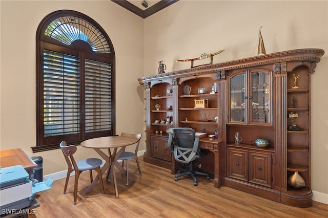 office area with light wood-type flooring and crown molding