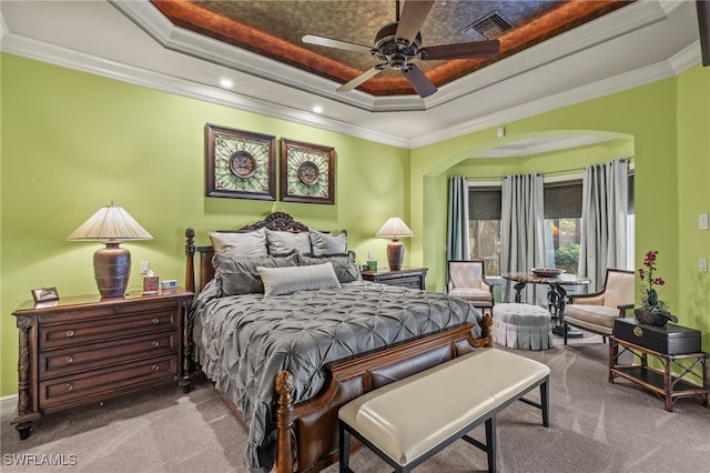 bedroom featuring a tray ceiling, ceiling fan, and ornamental molding