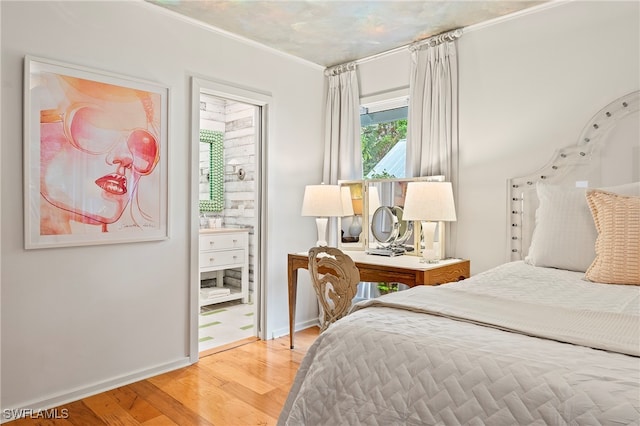 bedroom with ornamental molding and light hardwood / wood-style flooring