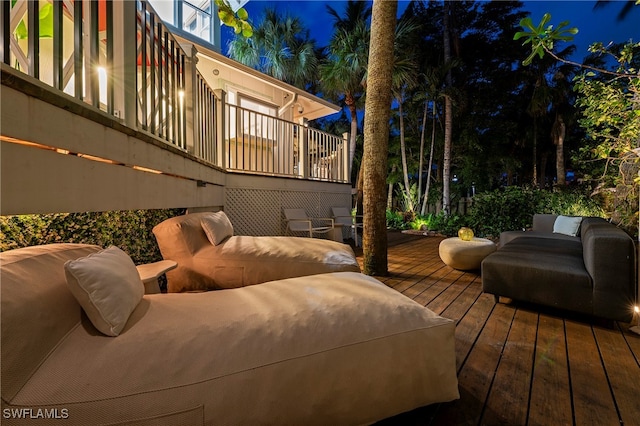 deck at night featuring an outdoor hangout area