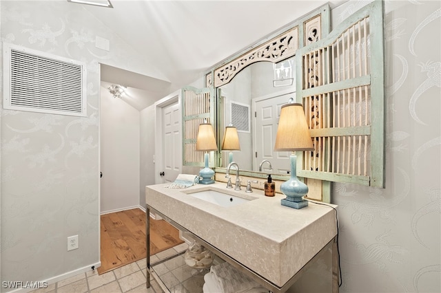 bathroom with sink, lofted ceiling, and hardwood / wood-style flooring