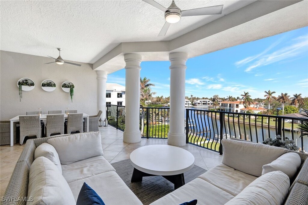 view of patio / terrace featuring ceiling fan, a water view, an outdoor living space, and a balcony