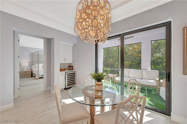 dining area featuring beverage cooler, ornamental molding, and a notable chandelier