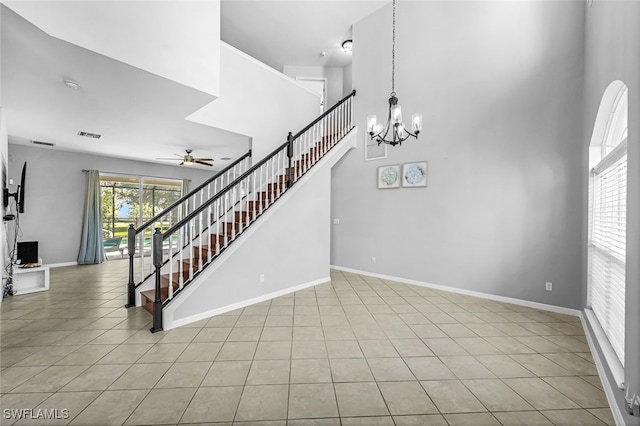 stairway featuring tile patterned floors and ceiling fan with notable chandelier