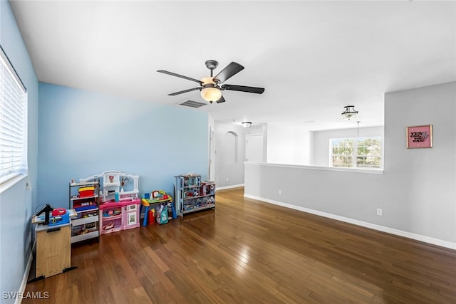 rec room with ceiling fan and dark wood-type flooring