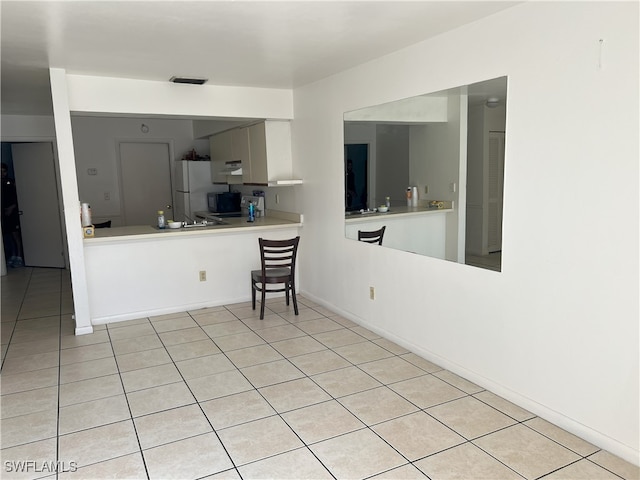 kitchen with white refrigerator and light tile patterned flooring