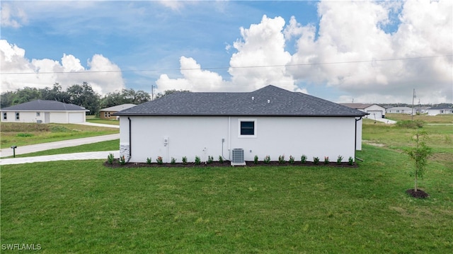 view of side of home with a lawn and central AC