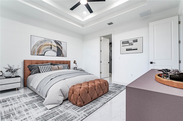 bedroom with a raised ceiling and ceiling fan