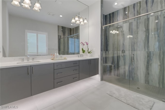 bathroom featuring tile patterned floors, a shower with door, and vanity