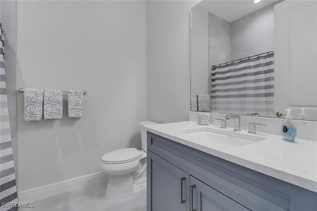 bathroom featuring tile patterned flooring, vanity, and toilet