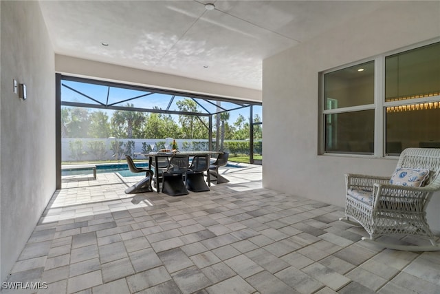 view of patio featuring a lanai