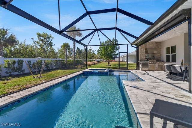 view of pool with glass enclosure, exterior kitchen, and a patio