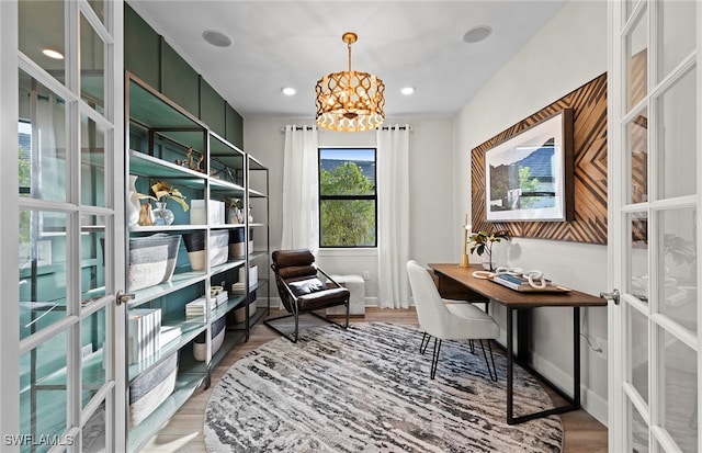 home office featuring a chandelier, light hardwood / wood-style flooring, and french doors