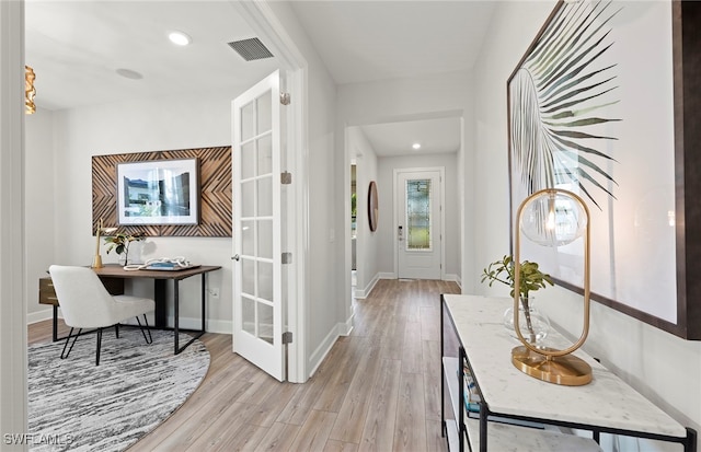 hall with french doors and light hardwood / wood-style flooring