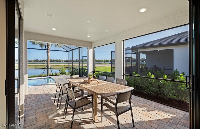 sunroom featuring a water view and a wealth of natural light