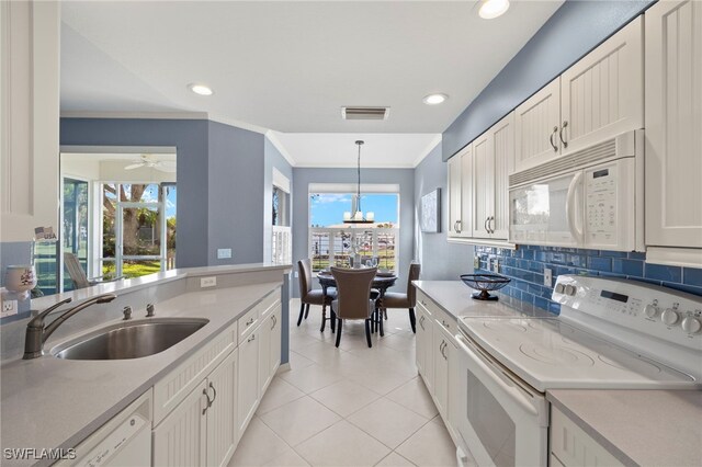 255 Cays Dr Unit 2001, Naples, FL 34114 - kitchen with white appliances, a sink, light countertops, light tile patterned floors, and decorative light fixtures