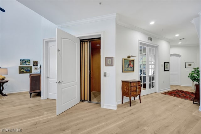 hall with ornamental molding, french doors, and light hardwood / wood-style flooring