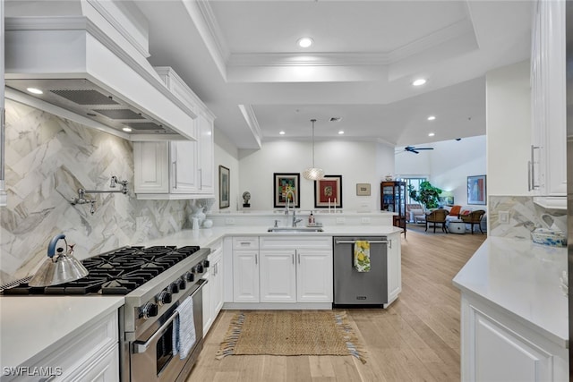 kitchen with kitchen peninsula, appliances with stainless steel finishes, custom exhaust hood, sink, and light hardwood / wood-style flooring