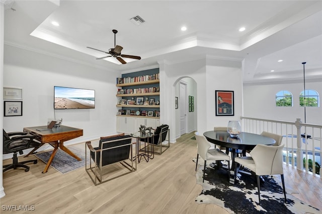 dining space with a tray ceiling, light hardwood / wood-style flooring, ceiling fan, and crown molding