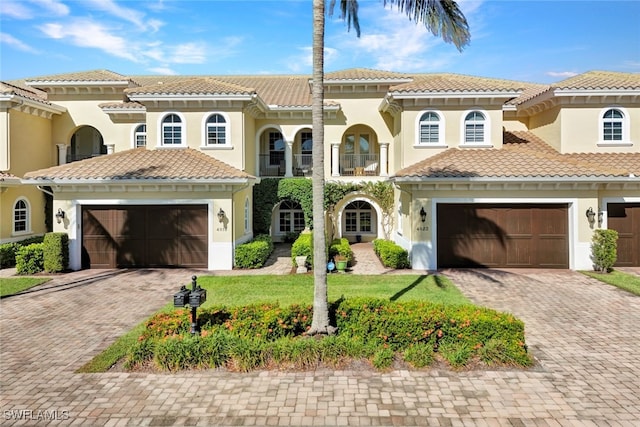 mediterranean / spanish-style house featuring a garage and a front yard