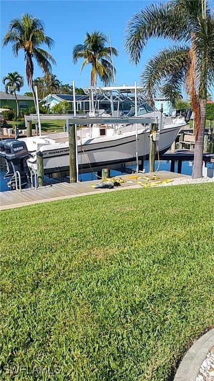 dock area featuring a lawn and a water view