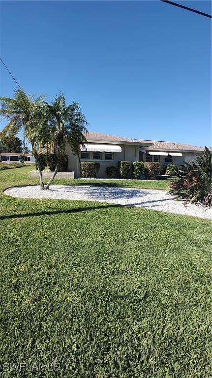 view of front of house featuring driveway, a front yard, and stucco siding