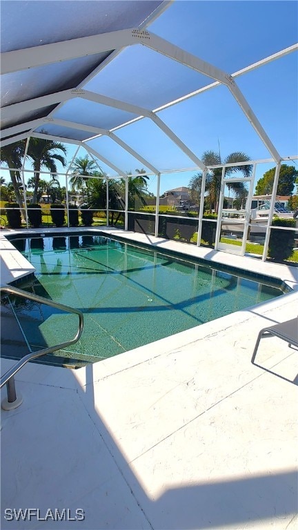 outdoor pool with glass enclosure and a patio area