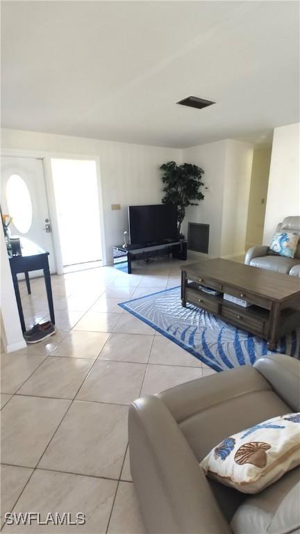 living area featuring visible vents and light tile patterned flooring