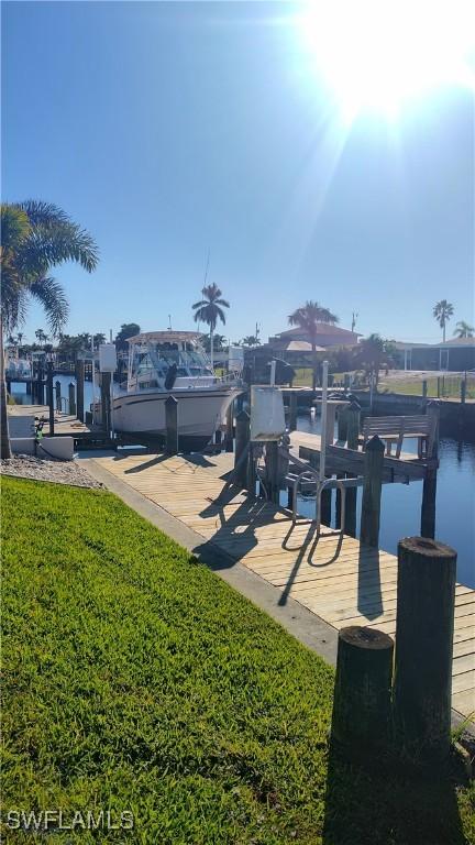 view of dock featuring a yard and boat lift