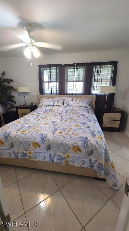 bedroom with a ceiling fan, multiple windows, and light tile patterned flooring