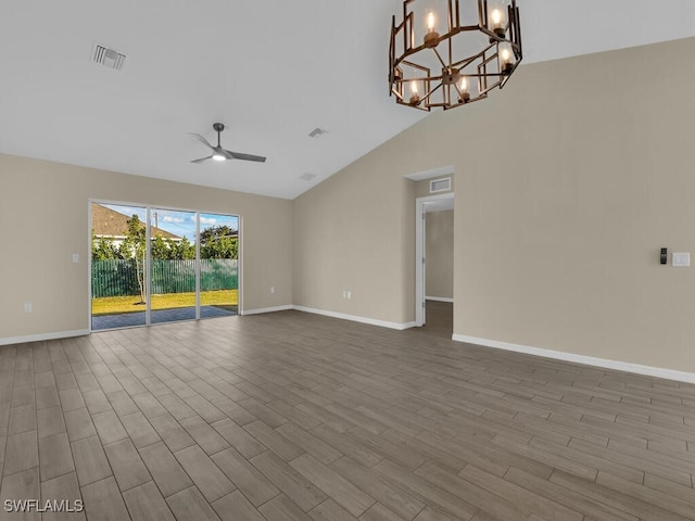 unfurnished room featuring ceiling fan with notable chandelier, high vaulted ceiling, and light hardwood / wood-style flooring