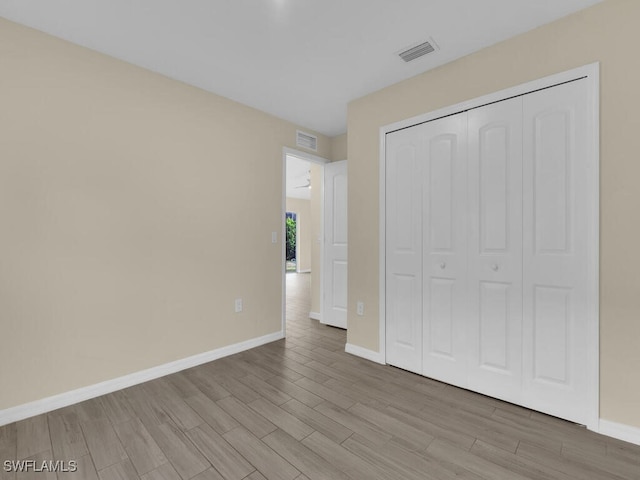 unfurnished bedroom with a closet and light hardwood / wood-style flooring