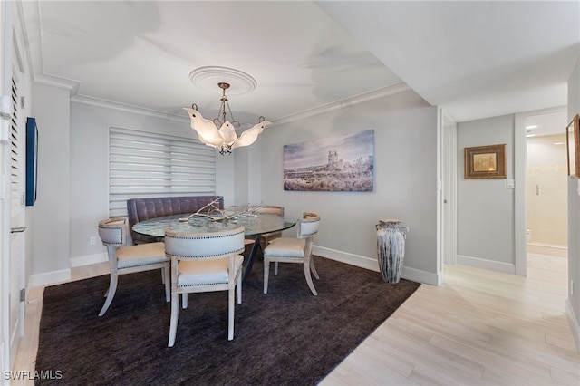 dining area featuring a notable chandelier, light hardwood / wood-style floors, and crown molding