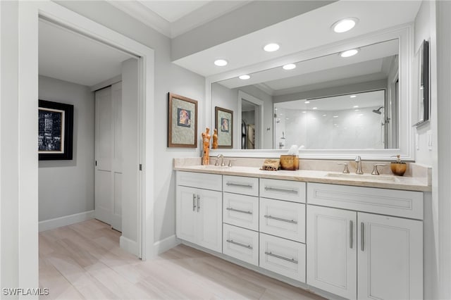 bathroom featuring walk in shower, vanity, wood-type flooring, and ornamental molding