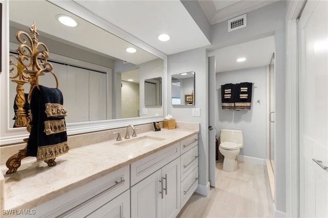 bathroom featuring vanity, toilet, and a shower with shower door