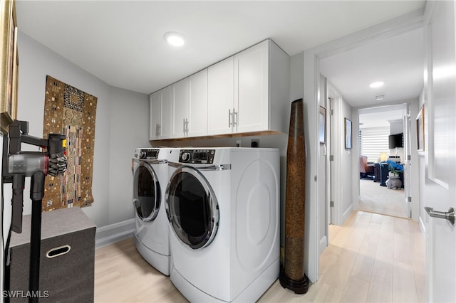 clothes washing area with independent washer and dryer and light wood-type flooring