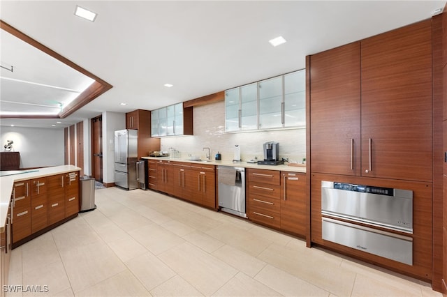 kitchen with decorative backsplash, appliances with stainless steel finishes, light tile patterned floors, and sink