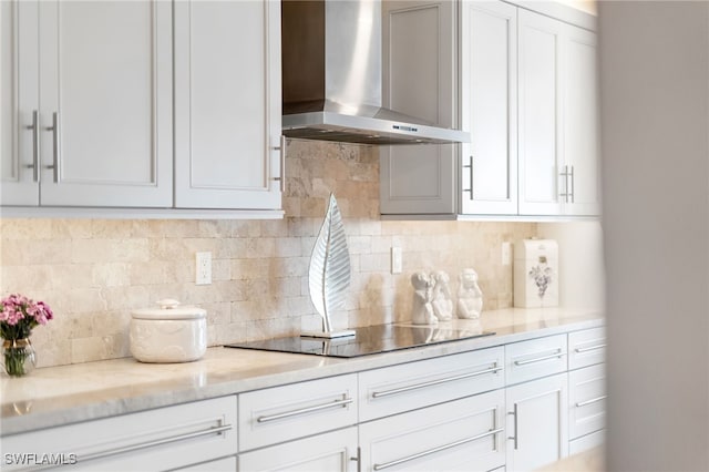 kitchen featuring white cabinets, wall chimney range hood, backsplash, and black electric cooktop