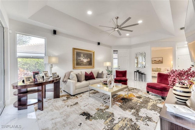 living area featuring recessed lighting, visible vents, a raised ceiling, and a ceiling fan