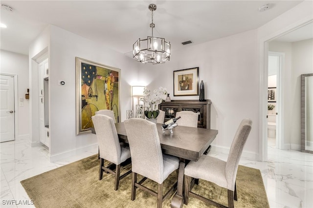 dining space featuring visible vents, baseboards, marble finish floor, and a chandelier