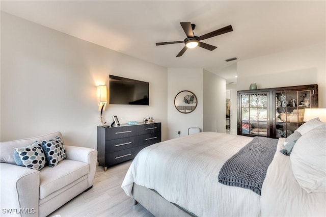 bedroom featuring visible vents, light wood-style floors, and ceiling fan