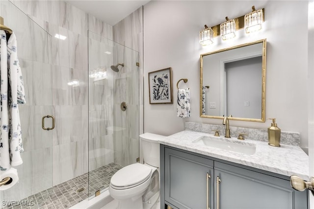 bathroom featuring vanity, a shower stall, and toilet