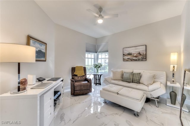 living area with a ceiling fan, marble finish floor, and baseboards